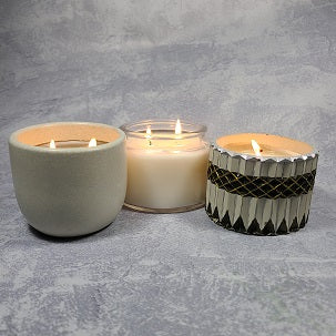3 lit candles in decorative jars